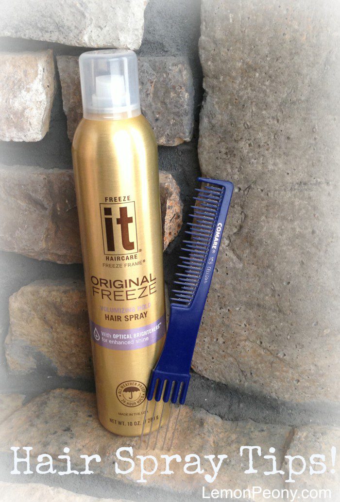 A bottle of cheap hair spray and a comb next to a brick wall.