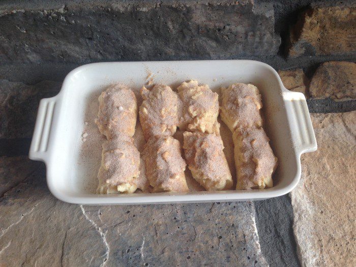 Easy Cinnamon Rolls in a baking dish on a stone fireplace.