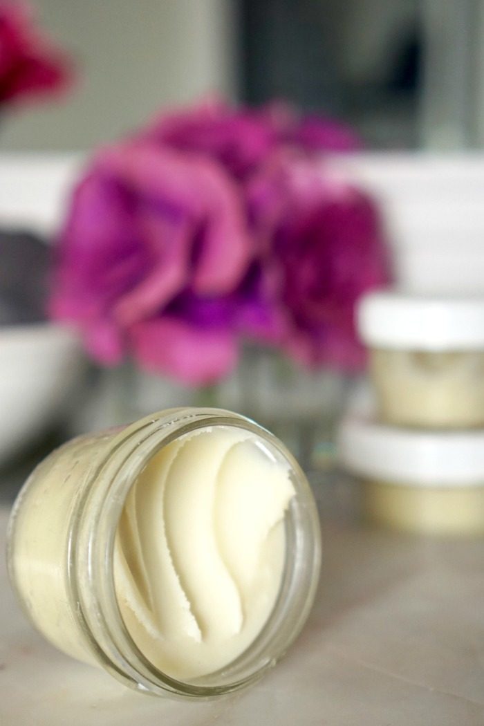 A jar of DIY homemade body butter sitting on a counter.