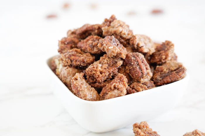 Candied pecans in a white bowl.