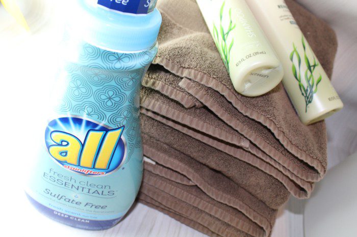 A bottle of laundry detergent sits on top of a towel, representing one of the 5 Healthy Home Hacks.