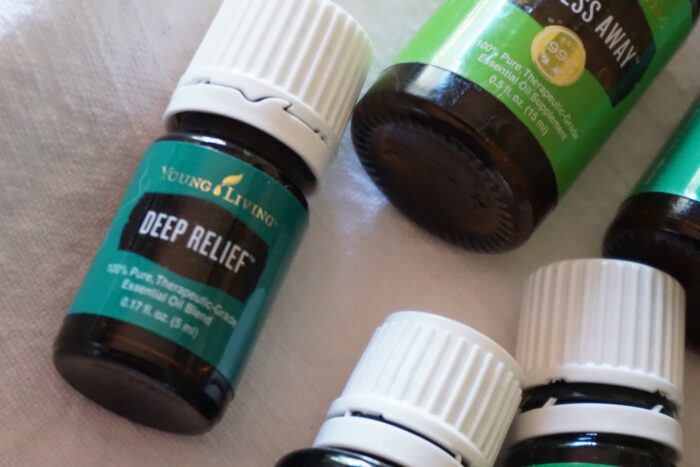 Four bottles of essential oils for St. Patrick's Day on a white table.