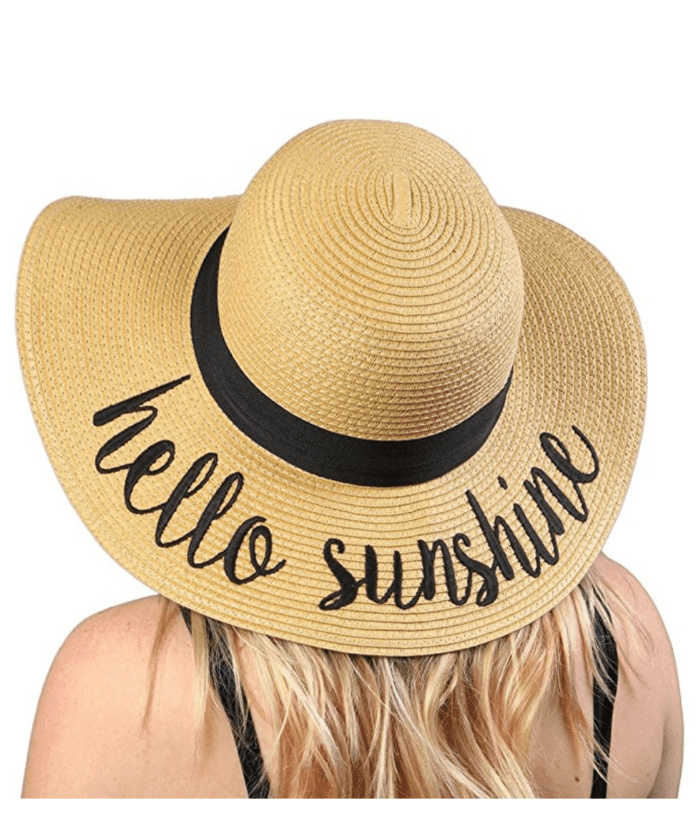 A woman wearing a cute hat that says hello sunshine.