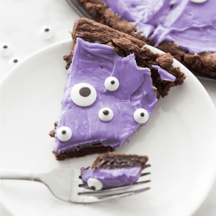 A purple pie with eyes on it, an easy Halloween treat for kids, on a plate.