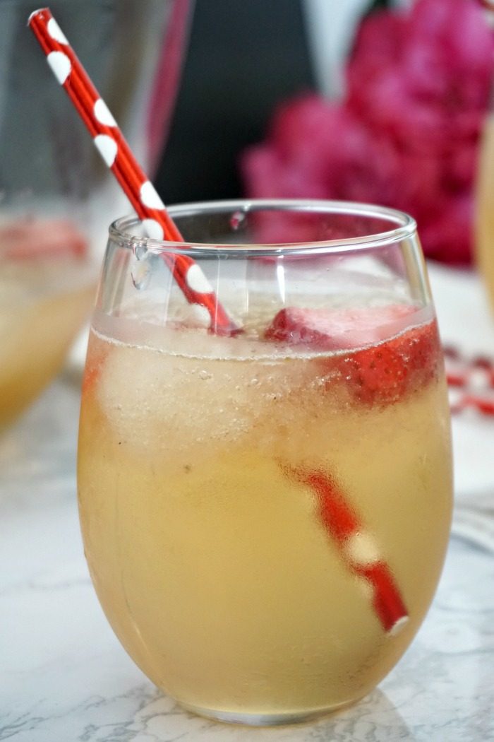 A glass of Valentine's Day Punch with red and white straws.