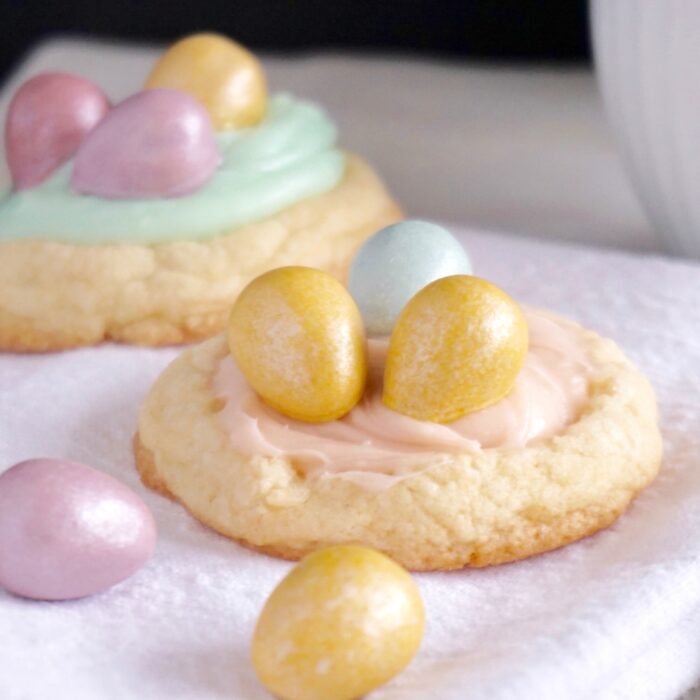 Easter Cadbury Birds Nest cookies with colored eggs on a towel.