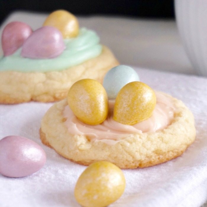 Easter Sugar Cookies with colored eggs on a towel.