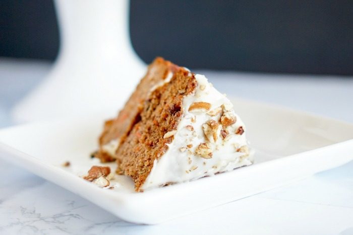 A slice of the best simple carrot cake on a white plate.