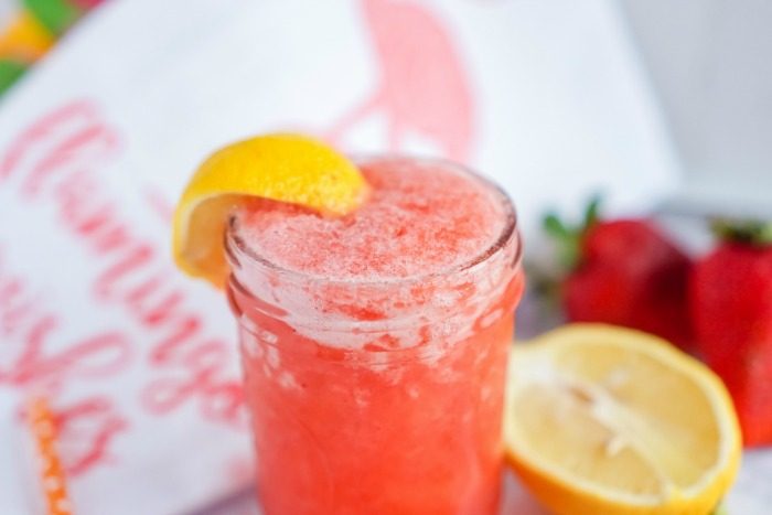 A strawberry lemonade in a glass with a lemon slice from an easy recipe.