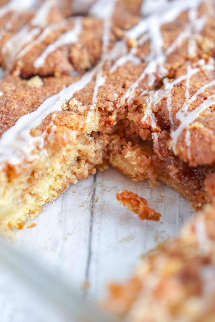 A slice of apple cinnamon coffee cake with pecans and icing.