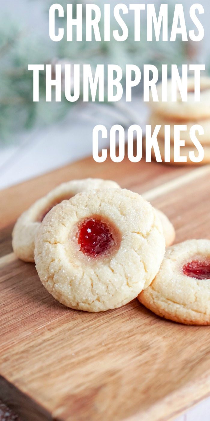 Christmas thumbprint sugar cookies on a cutting board.