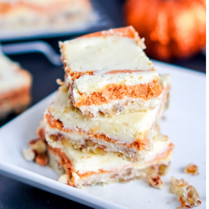 Amazing Pumpkin cheesecake bars stacked on a plate.