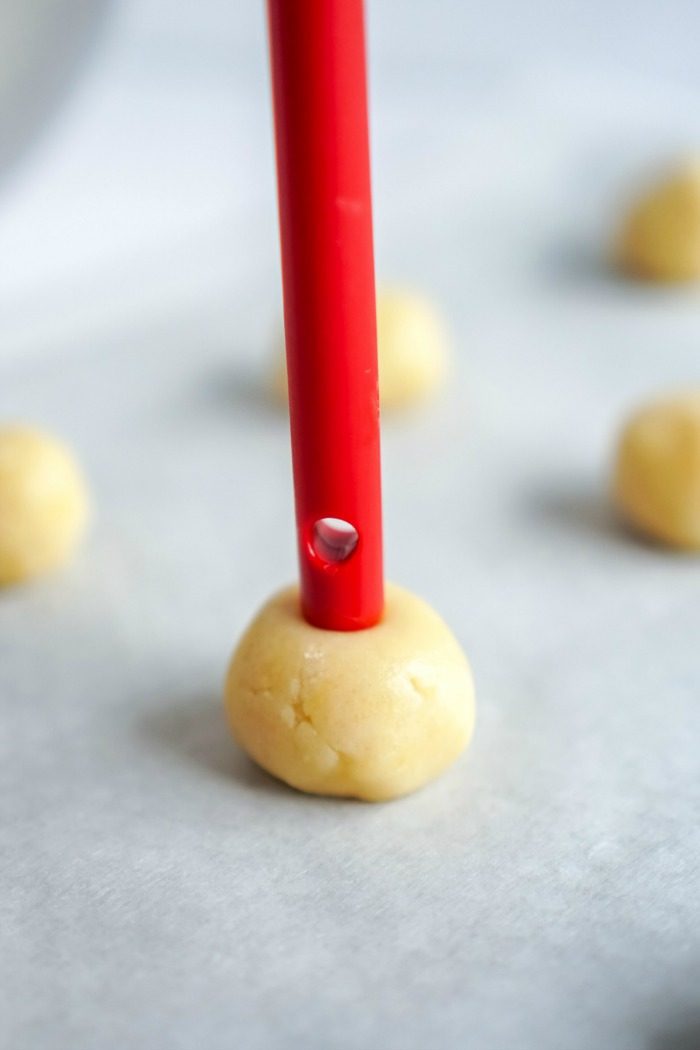 A red spoon is being used to make Christmas doughnuts.