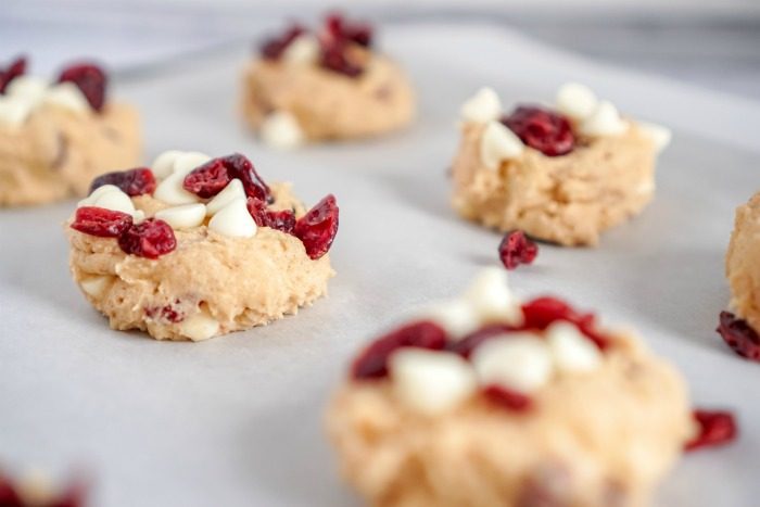 Cranberry white chocolate chip cookies on a baking sheet.