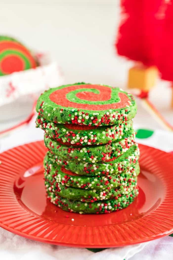 A stack of amazing green and red cookies on a red plate.