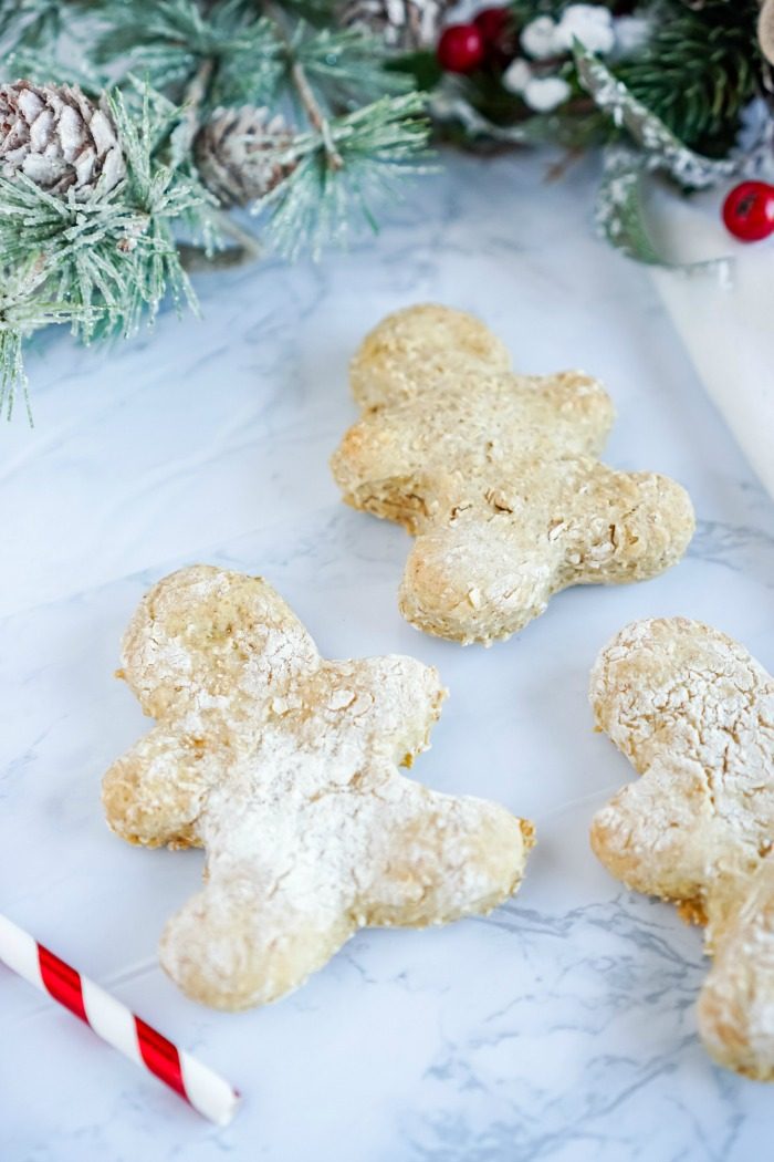 Three homemade gingerbread cookies on a marble table.