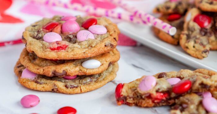 A stack of the best M&M Valentine's Day cookies on a white plate.