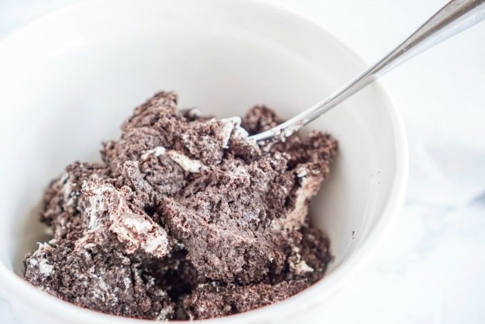 A bowl of No Bake Oreo Cheesecake Balls with a spoon in it.