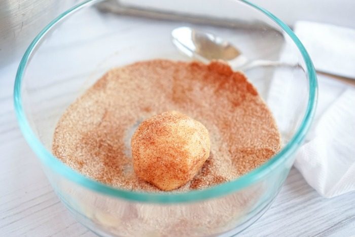 A bowl of cinnamon and sugar with a spoon in it for an easy Snickerdoodle recipe without Cream of Tartar.