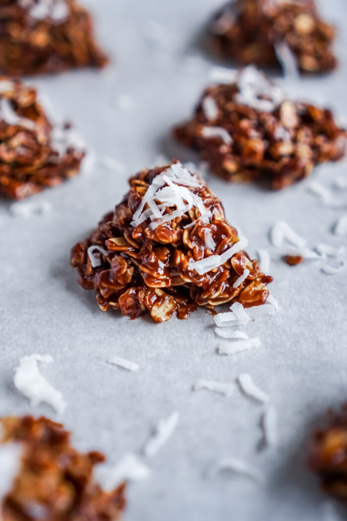 A plate of peanut butter no bake cookies with coconut sprinkled on top.