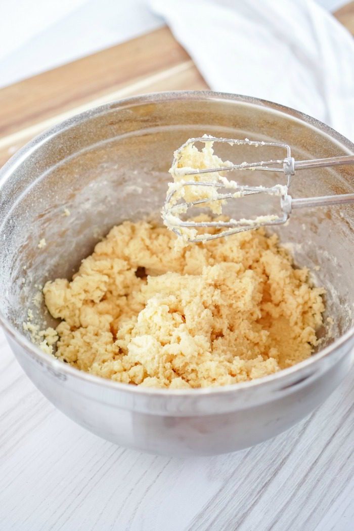 A bowl of Easy Snickerdoodle dough without Cream of Tartar with a whisk in it.