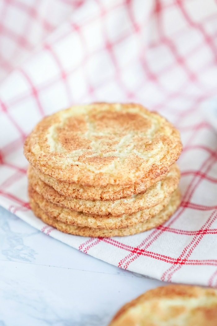 A stack of easy Snickerdoodle cookies without Cream of Tartar on a red and white checkered napkin.