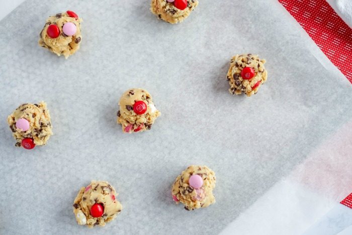 Best Valentine's day M&M cookies on a baking sheet.