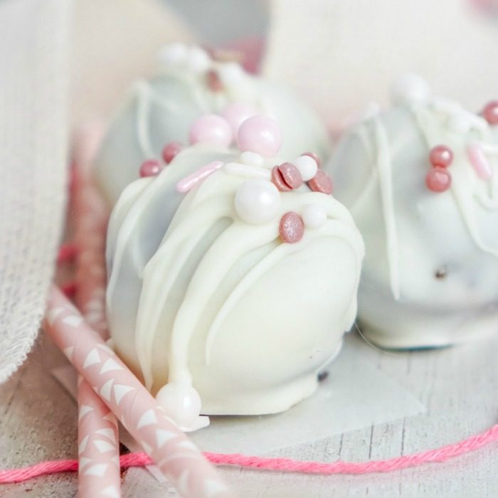 Three easy no-bake white chocolate truffles with pink sprinkles, perfect for Valentine's Day.