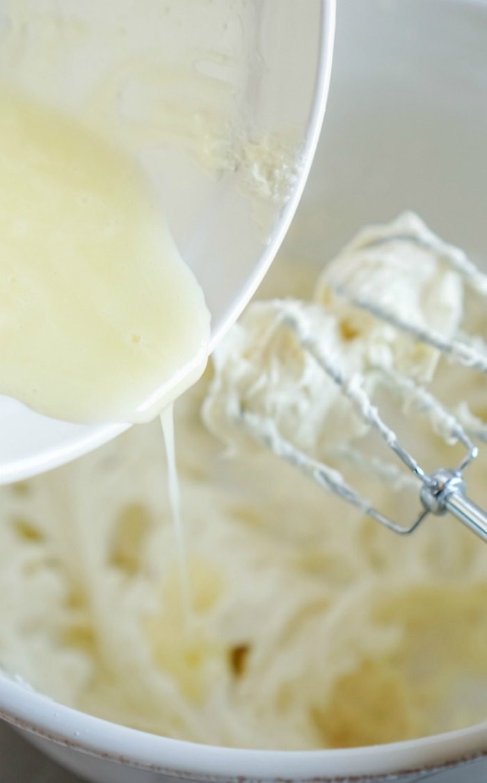 Whipping cream in a bowl with a whisk for an Easter No Bake Mini Cheesecake recipe.