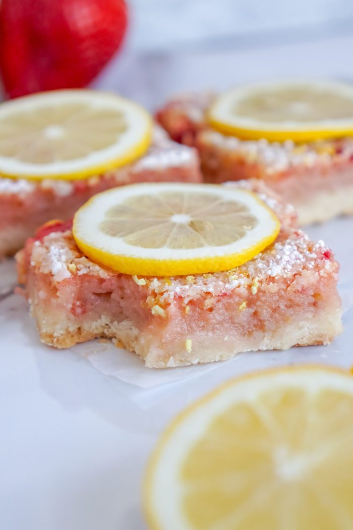 Strawberry Lemon Bars Recipe with powdered sugar and lemon slices.