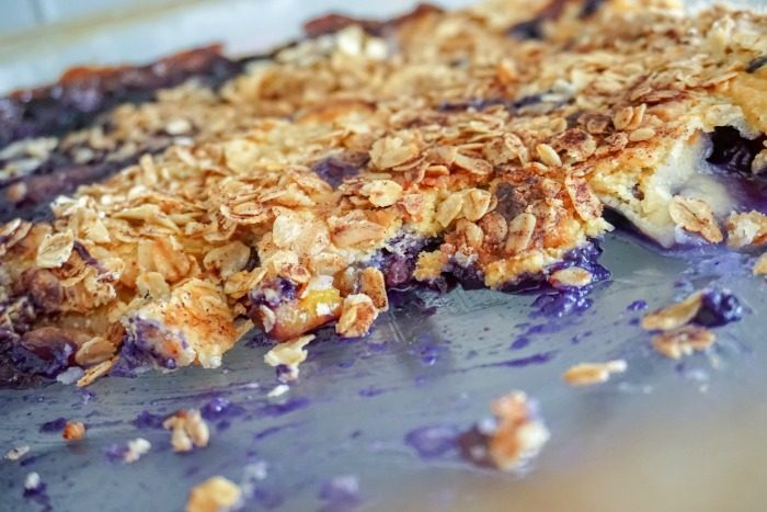 A close-up of a blueberry cobbler with an oat crumble topping.