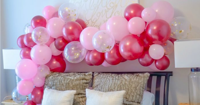Balloons in pink, red, and white arranged in a curve.