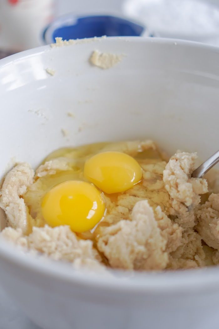 Two raw eggs in a white bowl.