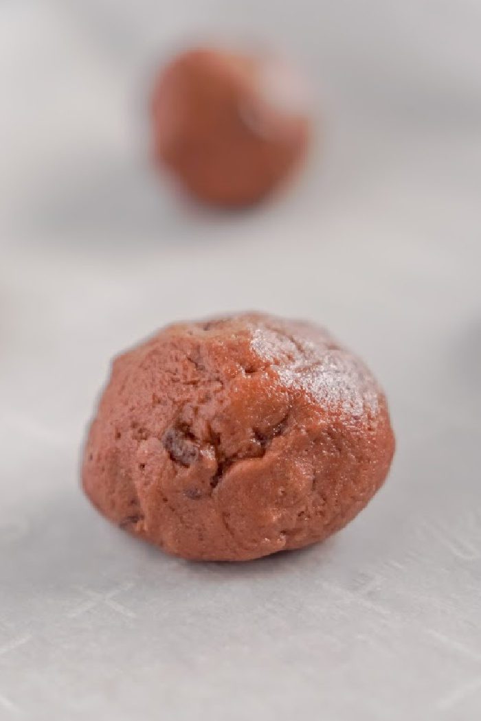 A close-up image of a red cookie dough ball.