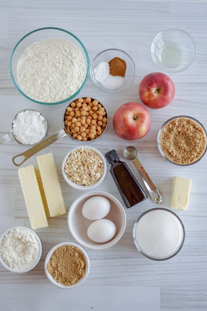 Ingredients for making apple pie arranged on a table.