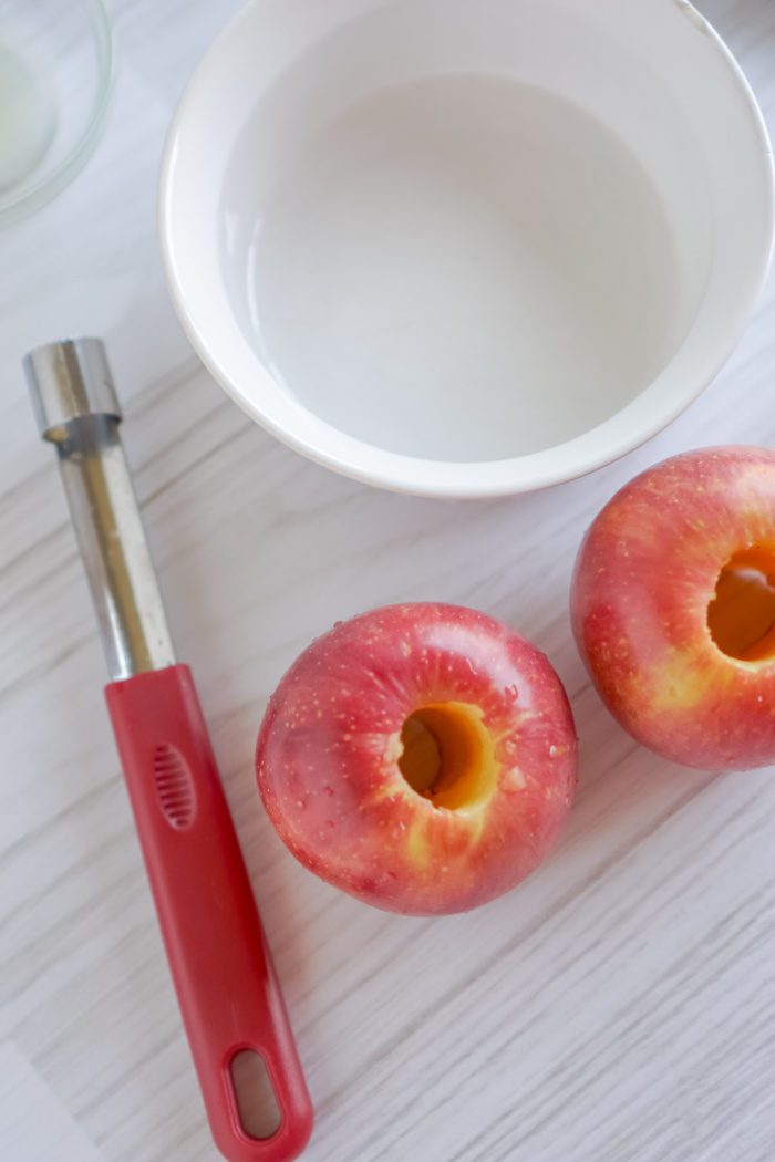 Two cored apples and an apple corer.