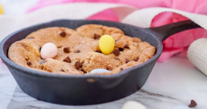 Cookie in a skillet with chocolate chips and candy eggs.