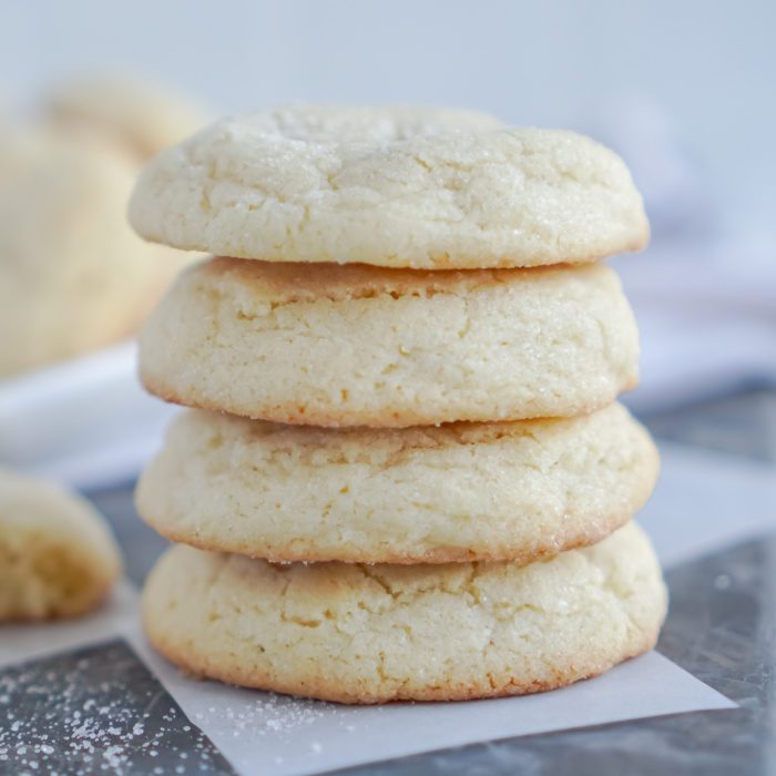 A stack of four soft sugar cookies.