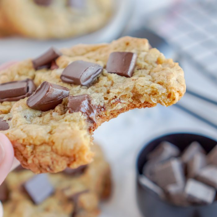 A close-up image of a bitten chocolate chip cookie.