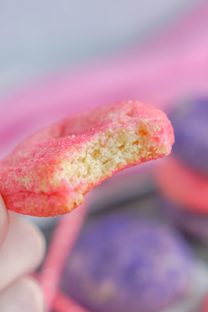 A close-up image of a bitten pink sugar cookie.