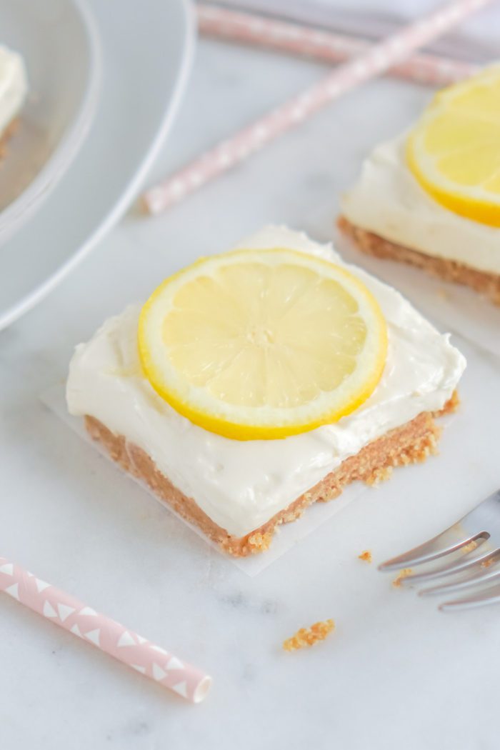 A square lemon bar with a lemon slice on top.