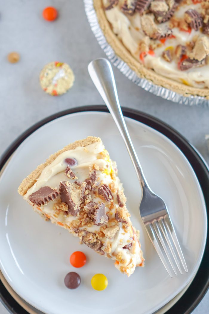 A slice of peanut butter pie with a fork on a white plate.