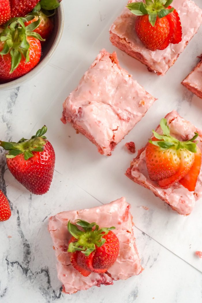 A photo of strawberry poke cake squares.