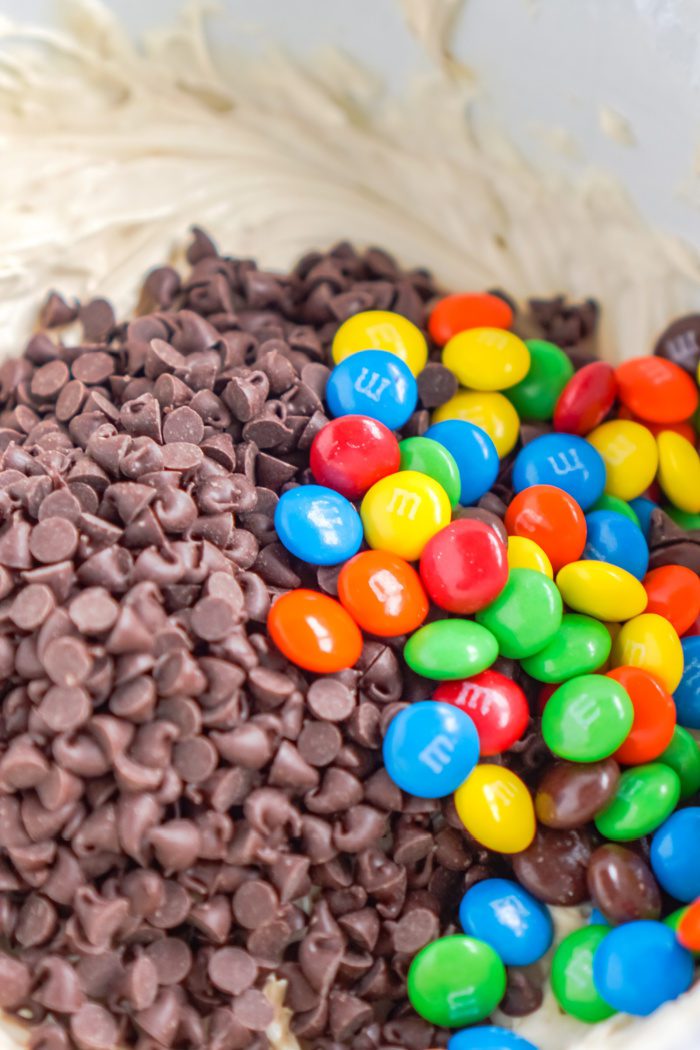 Chocolate chips and colorful candies in a bowl.