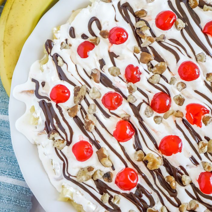 Banana split dessert with chocolate syrup and nuts.