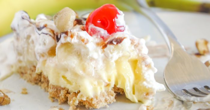 A slice of banana split pie with cherry on top.