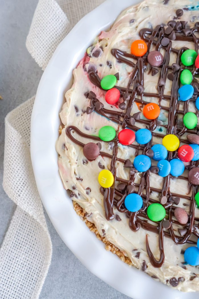 A cheesecake with rainbow sprinkles and chocolate chips.