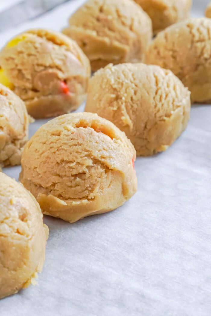 Peanut butter cookie dough balls with candy pieces.