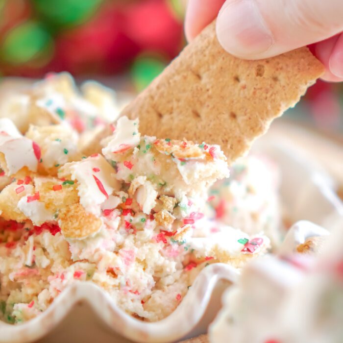 Graham cracker dipping into Christmas cake dip