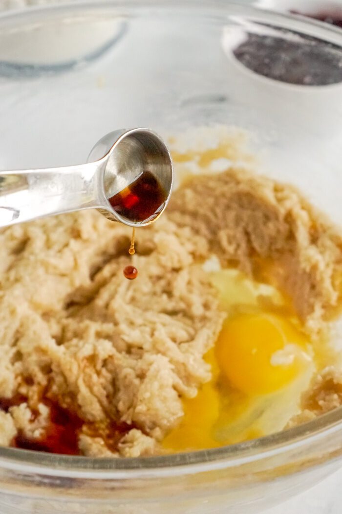 Adding vanilla and egg to bowl